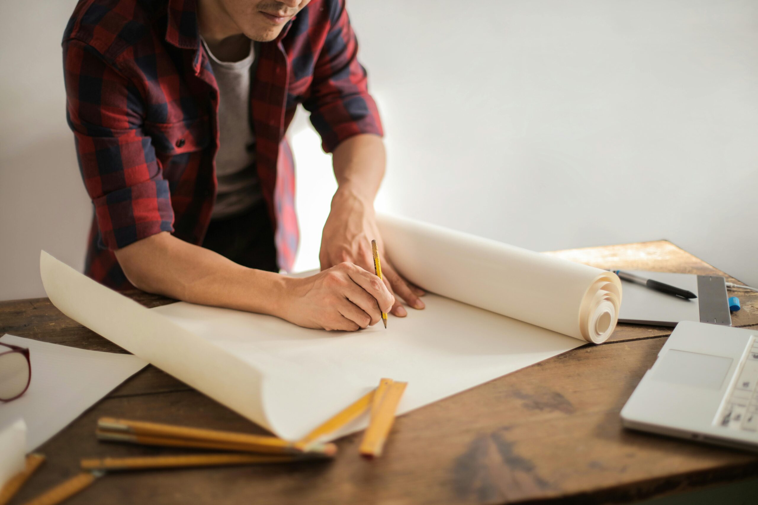 Person reviewing home building plans with a permit in hand