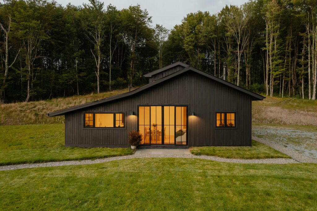 Modern custom home built by Utah contractors featuring large windows and wooded lot setting