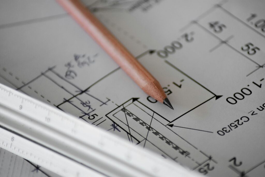 Custom floor plan design process with pencil on architectural blueprints for Utah custom home builder