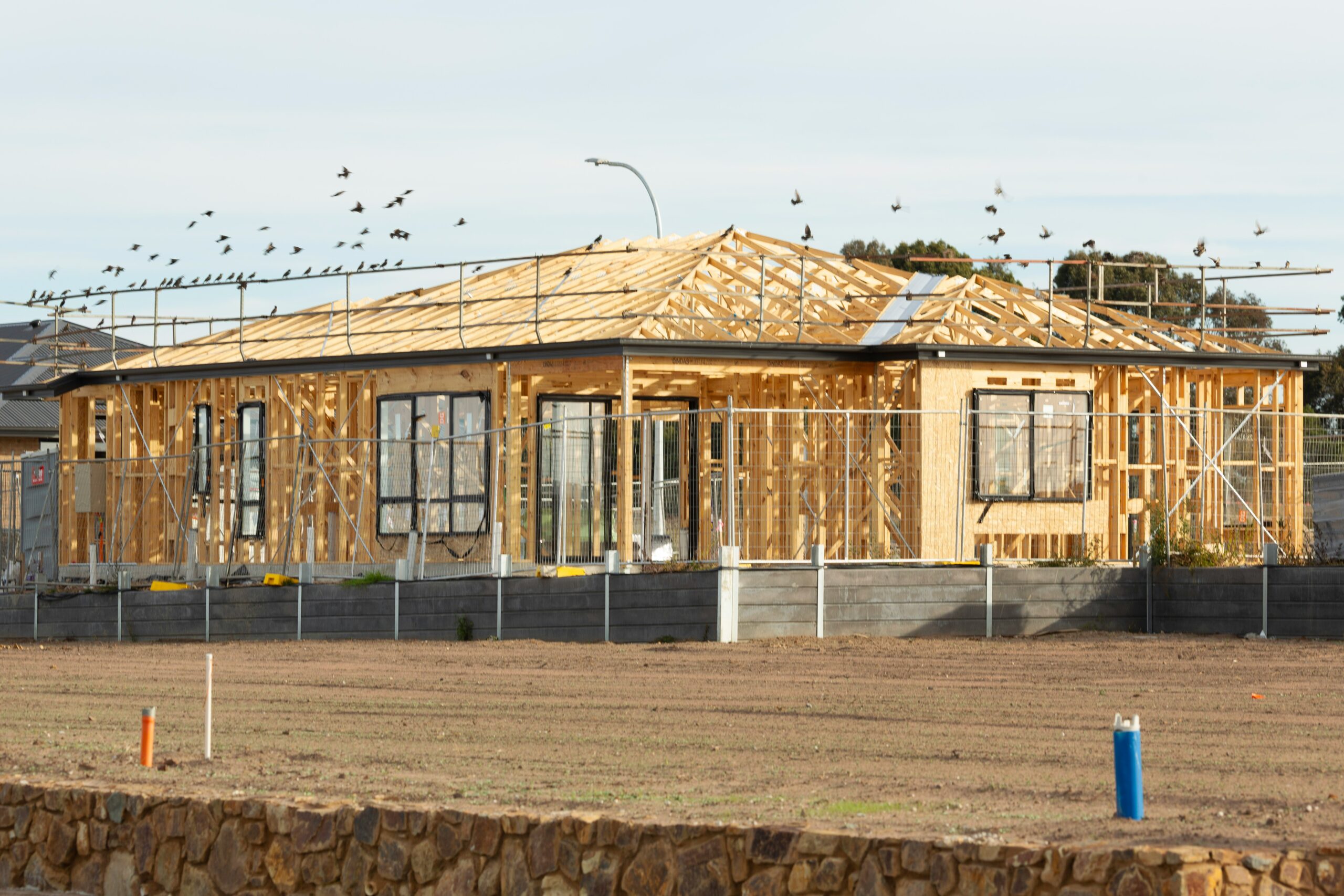 A new custom home in Utah under construction with exposed wooden framing and scaffolding