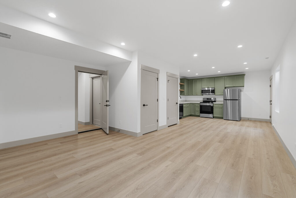 Open layout space with custom green cabinet kitchen.