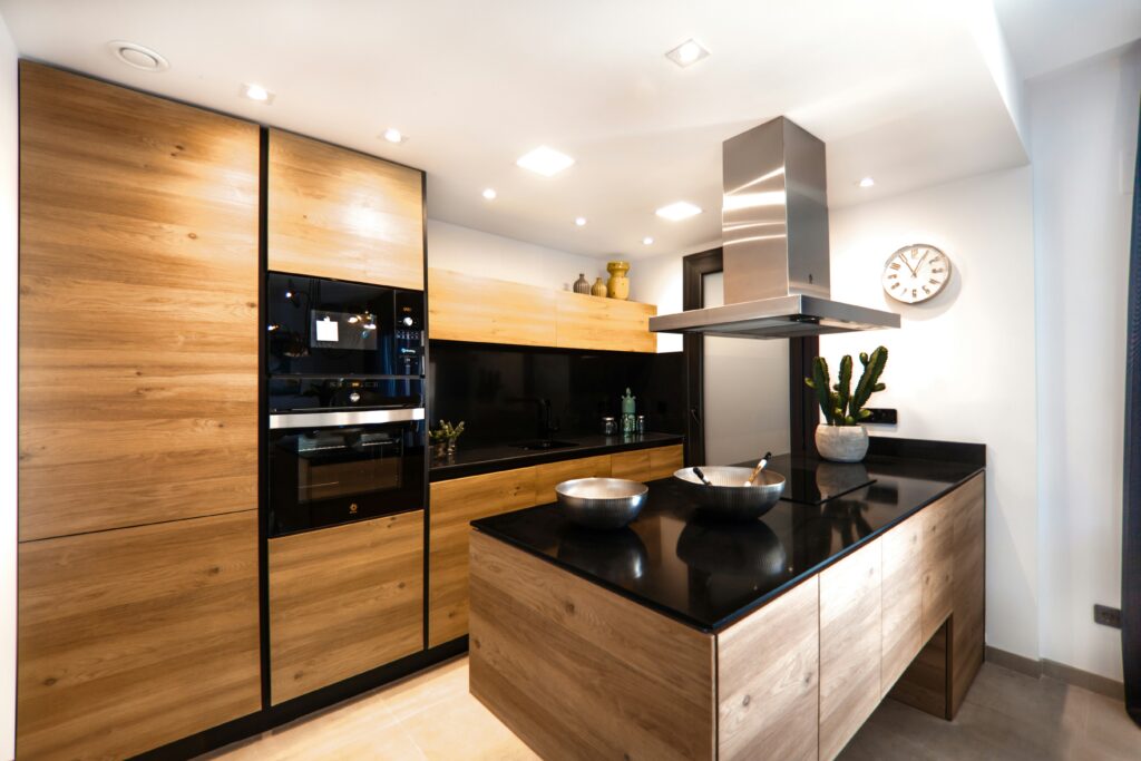 Contemporary kitchen renovation with wood kitchen cabinets, black countertops, and built-in appliances.