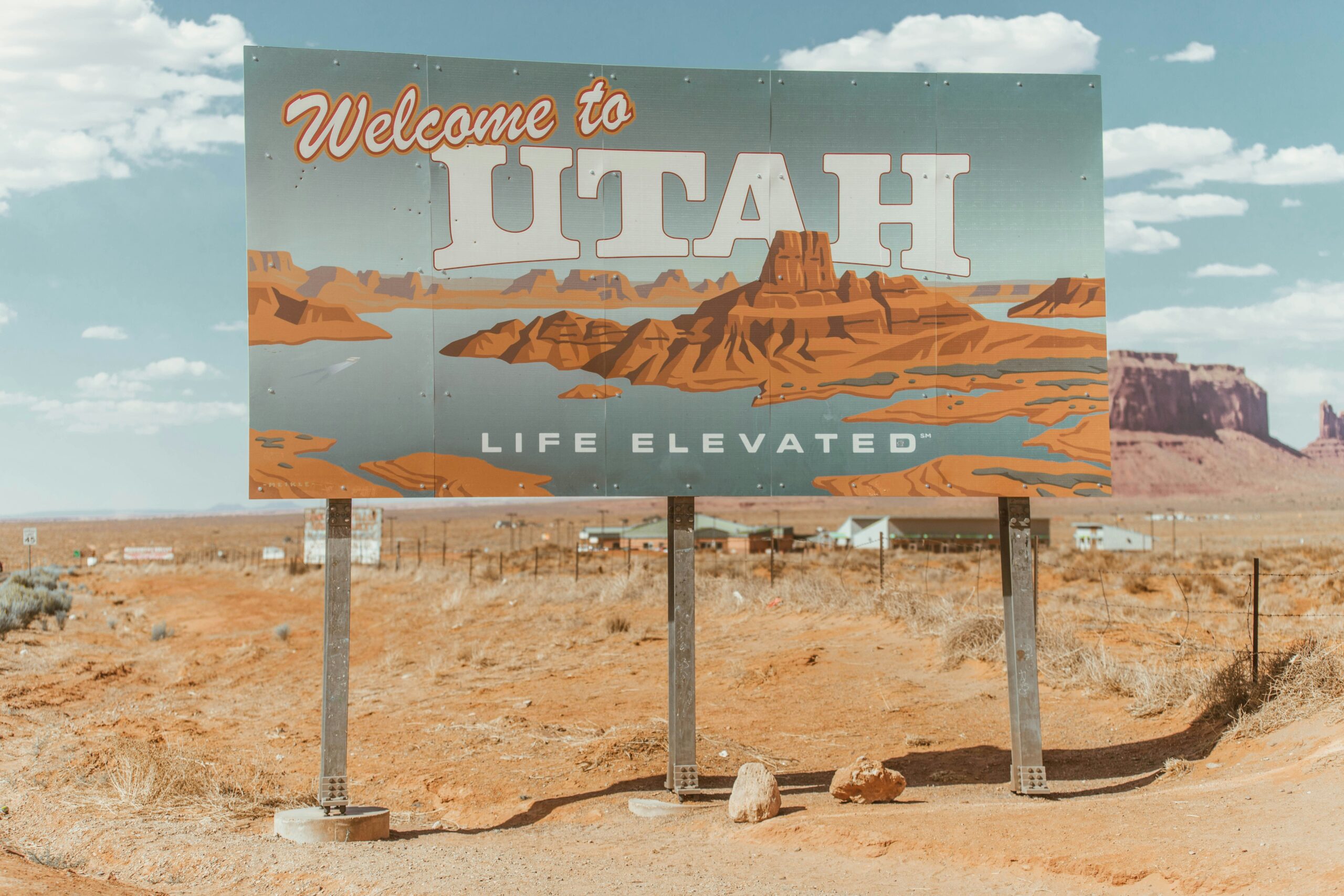 Welcome to Utah - Life Elevated highway sign with red rock scenery